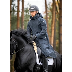 Stierna SKY Rain Coat /Navy – lang vandtæt regnfrakke til mænd med hætte, refleksdetaljer og sadelbeskyttelse til ridning. - Modelfoto af rytter til hest - set forfra